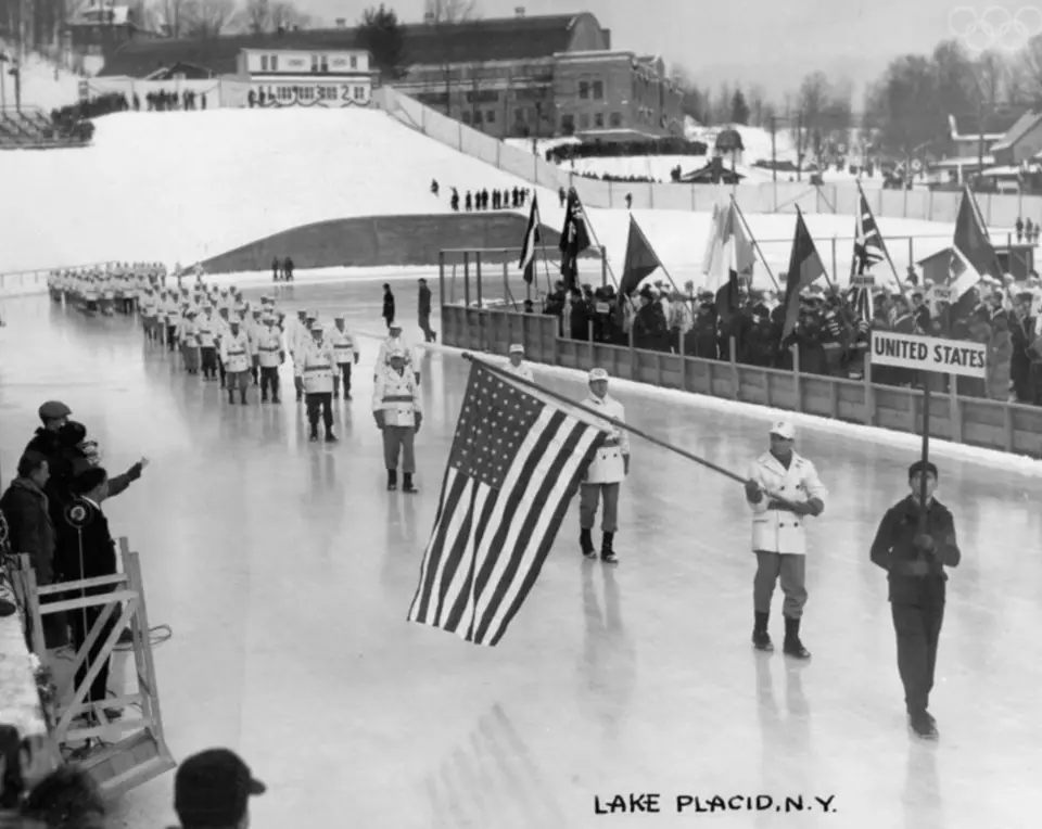 A black and white image of an early Olympic Winter Games opening ceremony.